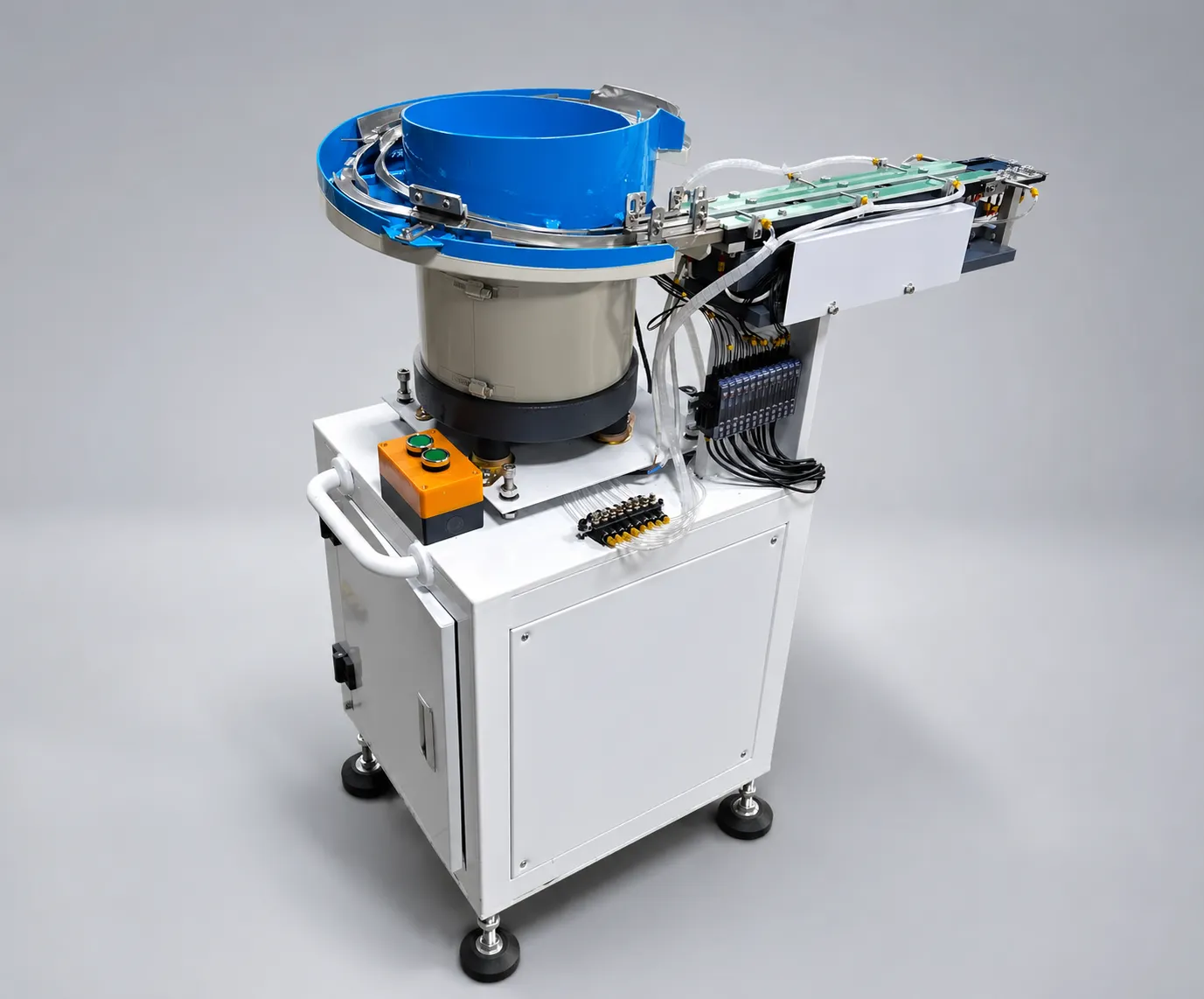 Single-bowl DPS-2 lens feeder with its discharge track and control cabinet, photographed in the studio